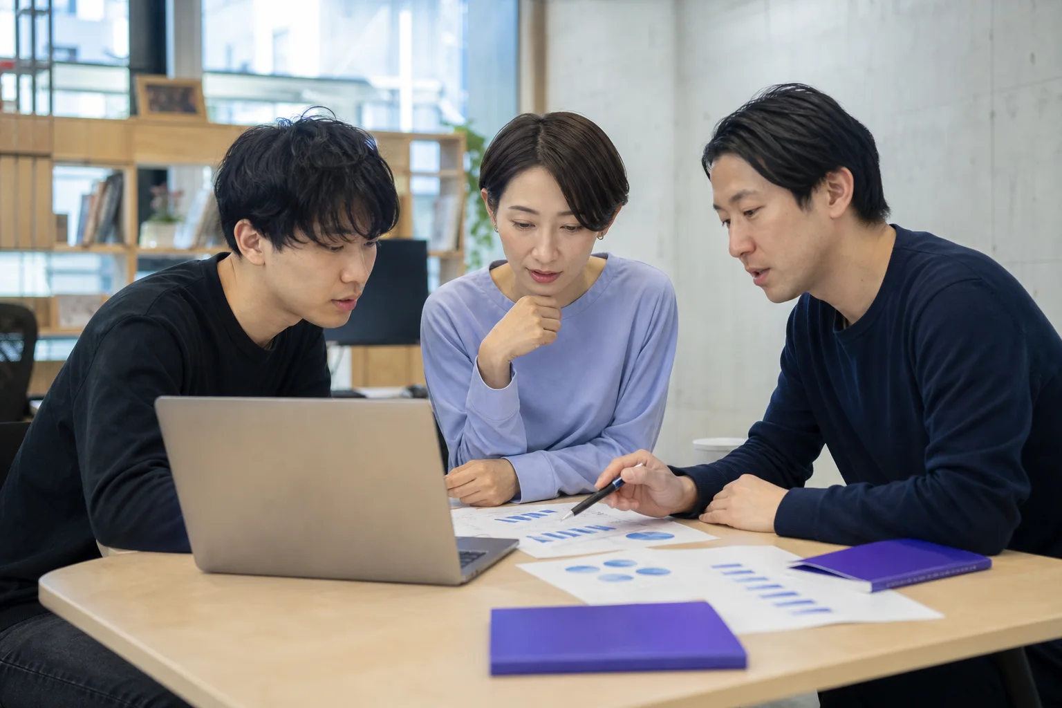 アンケート結果を確認しながら商品・広告・販促の改善を検討する担当者